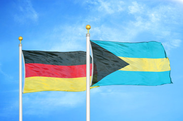 Germany and Bahamas two flags on flagpoles and blue cloudy sky