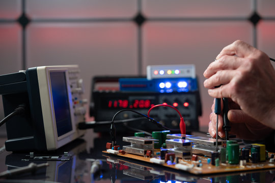 Debugging electronics device. PCB witch microcontroller in electronics laboratory