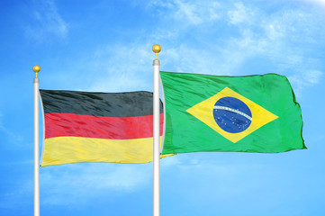 Germany and Brazil two flags on flagpoles and blue cloudy sky