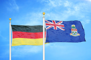 Germany and Cayman Islands two flags on flagpoles and blue cloudy sky