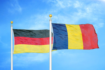 Germany and Chad two flags on flagpoles and blue cloudy sky
