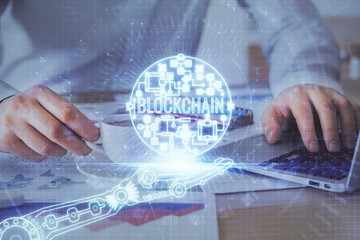 Crypto currency theme hologram with businessman working on computer on background. Concept of...