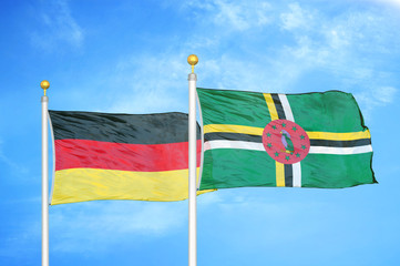 Germany and Dominica two flags on flagpoles and blue cloudy sky