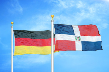 Germany and Dominican Republic two flags on flagpoles and blue cloudy sky