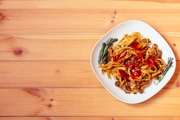 Pasta Fettuccine Bolognese with tomato sauce in white plate. Top view with copy space.