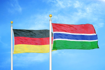 Germany and Gambia two flags on flagpoles and blue cloudy sky