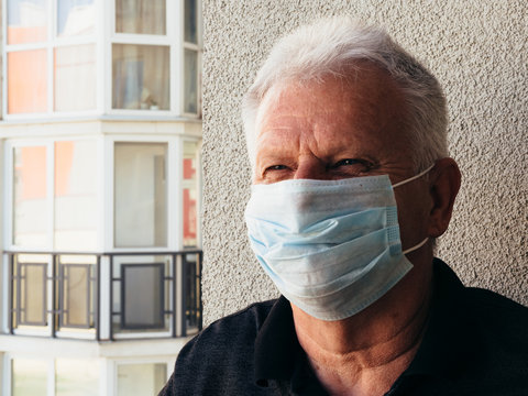Old man in a medical mask on the balcony of the house. quarantine. covid-19