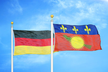 Germany and Guadeloupe two flags on flagpoles and blue cloudy sky