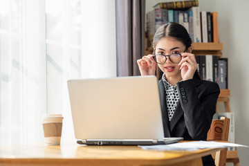 Young Asian business woman working in the office with laptop