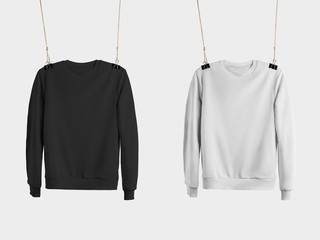 Mockup of black and white sweatshirts hanging on the ropes, empty pullovers for presentation of design, advertising in the online store.