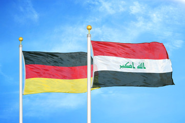 Germany and Iraq two flags on flagpoles and blue cloudy sky