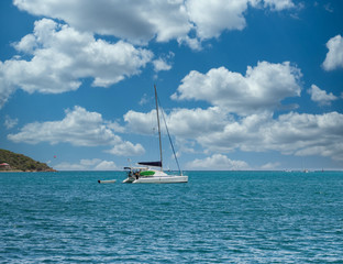 Naklejka premium A white sailboat with empty mast on blue water in the Caribbean