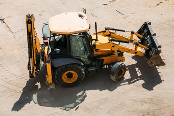 yellow tractor on the construction site on a sunny day view from above