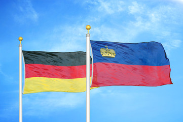 Germany and Liechtenstein two flags on flagpoles and blue cloudy sky