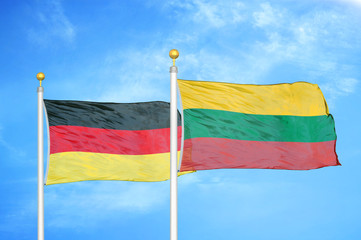 Germany and Lithuania two flags on flagpoles and blue cloudy sky