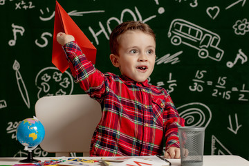 Home or school education. Pupil with paper airplane. Portrait child from elementary school.