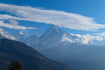 High mountains peak. White clouds. Green forest.
