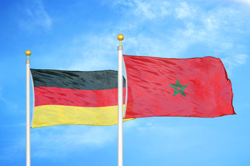 Germany and Morocco two flags on flagpoles and blue cloudy sky