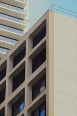 Cityscape with two builds and blue sky in the background. The building in the foreground is a multi...