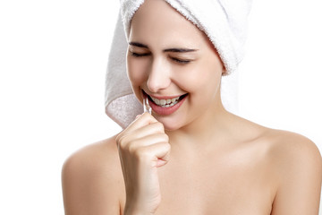 beautiful girl with a towel on her head brushes her teeth and toothpaste