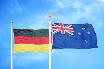 Germany and New Zealand two flags on flagpoles and blue cloudy sky
