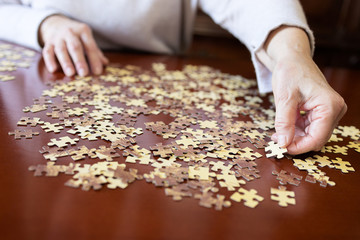 Old woman doing a jigsaw puzzle