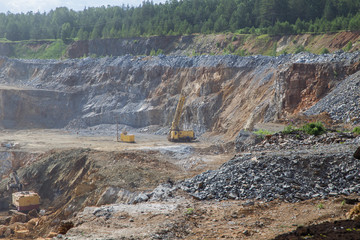 Big open pit magnezite quarry mine with working drilling machines, excavators, trucks