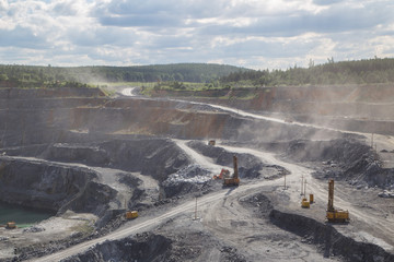 Big open pit magnezite quarry mine with working drilling machines, excavators, trucks
