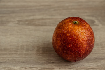 juicy red orange on a wooden table closeup, exotic fruit