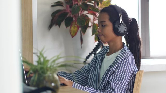 Freelancer woman working at home talking on online conference with headphone.