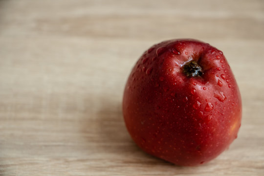 Juicy Dark Red Apple On A Wooden Table