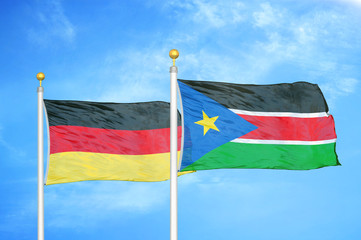 Germany and South Sudan two flags on flagpoles and blue cloudy sky