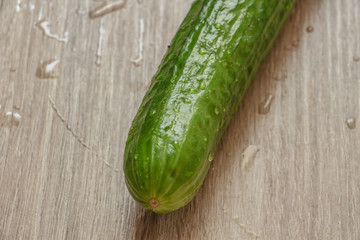 one juicy green cucumber on a wooden table