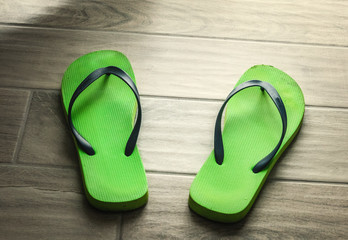 green flip flops on a grey floor