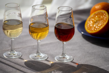 Glasses with cold dry fino and sweet cream sherry fortified wine in sunlights, andalusian style interior on background