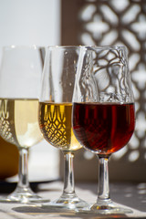 Glasses with cold dry fino and sweet cream sherry fortified wine in sunlights, andalusian style interior on background