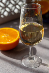 Glass with cold fino sherry fortified wine in sunlights, andalusian style interior on background