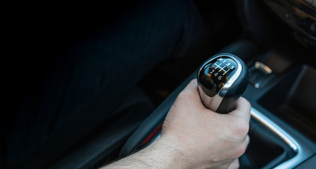 Close-up of a driver changing gear while driving