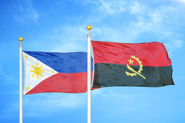 Philippines and Angola two flags on flagpoles and blue cloudy sky