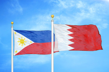 Philippines and Bahrain two flags on flagpoles and blue cloudy sky