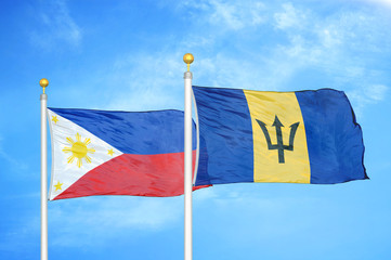 Philippines and Barbados two flags on flagpoles and blue cloudy sky