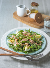Arugula and trout salad with egg and asparagus on a plate