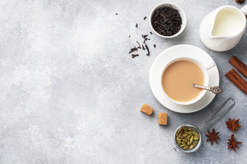 Indian drink masala tea with milk and spices. Cardamom sticks cinnamon star anise cane sugar....
