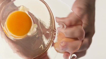 View from underneath glass of cracking an egg.