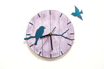 Wooden clock with birds on a white background close-up.