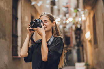 Blonde woman is taking photos of the city, she works for the city magazine and received an order for a couple of pictures representing all attractive views of the city, she use professional equipment.