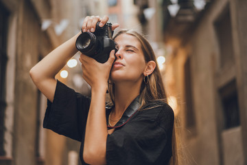 Blonde woman is taking photos of the city, she works for city magazine and received an order for a couple of pictures representing all attractive views of the city, she uses her professional equipment