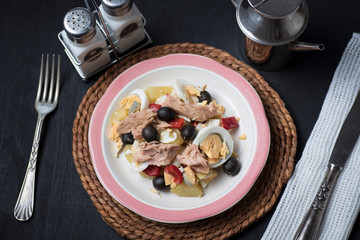 Potato salad with olives, tuna, boiled egg and its dressing. Delicious plate of Spanish food