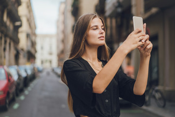 Girl is shooting a story for the Instagram, she uses her phone for publishing it, beautiful and attractive stories are important for success in blogging.