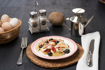 Potato salad with olives, tuna, boiled egg and its dressing. Delicious plate of Spanish food